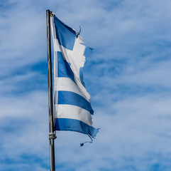 Zerrissene griechische Flagge am Mast im Wind