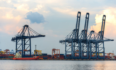 Container Cargo freight ship with working crane bridge in shipyard at dusk for Logistic Import...