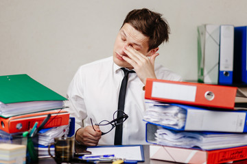Young businessman tired of working in the office at the end of the day
