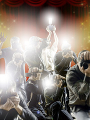 Crowd of paparazzi with flashing cameras in front a flashy background