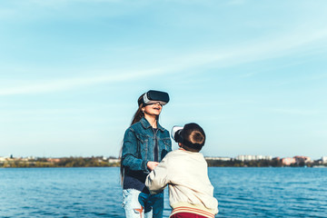 Fototapeta premium Sister with her little brother playing in VR glasses