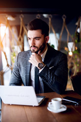 Man working on tablet, loking concentrated with hand on chin.