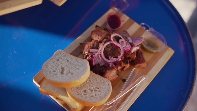 Close up footage of wooden tray with bread and barbecue in slowmotion