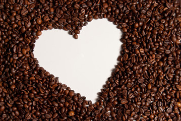 Coffee beans background forming a white heart 