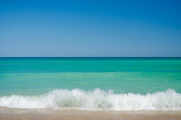 Waves crashing on the beach on a sunny day