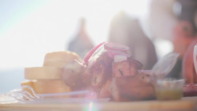 Close footage of fried meat and pieces of bread lying on wooden tray in slowmotion