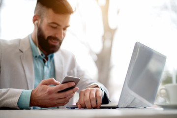 Side view of man in suit checking emails on smart watch.