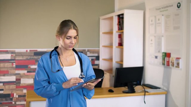 Portrait of female nurse with tablet at medical office. 4k