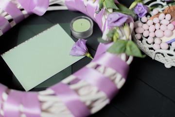 Green envelope template on black wooden background with flowers 