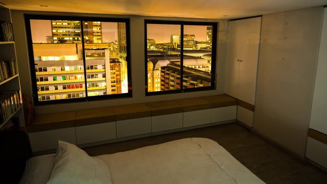 A linear dolly timelapse shot from a rooftop apartment building from inside a bedroom overlooking the Johannesburg city view at night, South Africa
