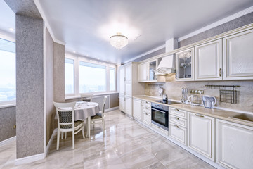 Fototapeta na wymiar Interior of white wooden kitchen in a spacious apartment in light colors.