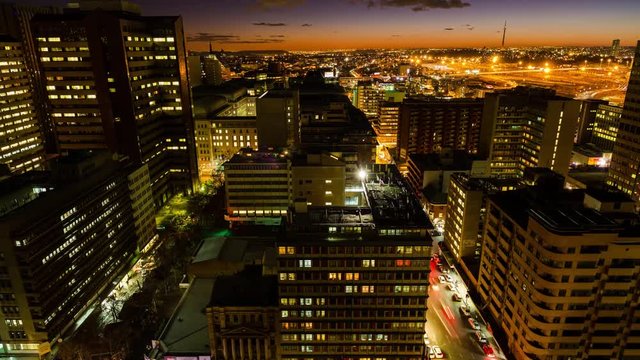 A timelapse of the city centre of Johannesburg (CBD) at night fall tilting down showing New Town and the Sentech Tower. during peak traffic time down Jeppe street, South Africa