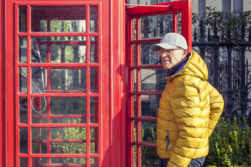 mature man walks into a red telephone box in London