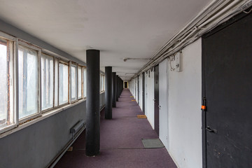Long walkway between buildings with carpet and doors