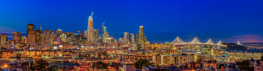San Francisco skyline panorama with city lights, the Bay Bridge and trail lights