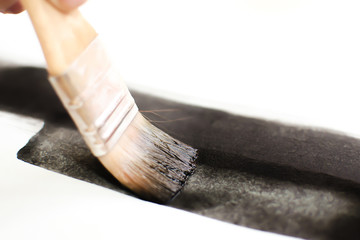 Drawing with watercolor paints on a white canvas. Artist at a master class drawing