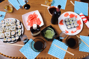 table with sushi set and wine with glasses