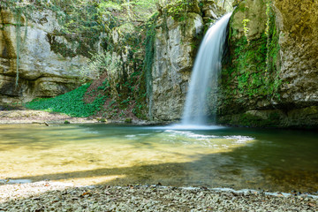 Fototapeta premium Idyllischer grosser Wasserfall mit Stein und Fels