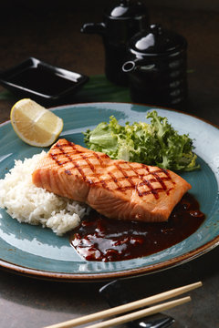 Grilled salmon with rice and sauce.