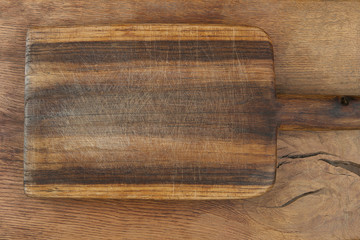 Cutting board on wooden table. Old grunge wooden cutting kitchen desk board background texture top view.