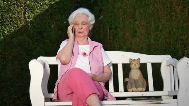 Seniorin beim telefonieren mit Smartphone