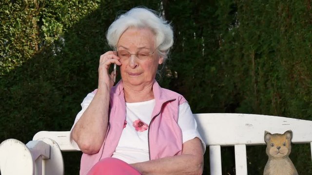 Seniorin beim telefonieren mit Smartphone