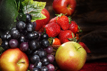 Juicy bright fruit, sprinkled with water, still life of seasonal fruits and berries