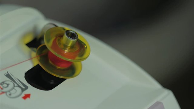 Spinning a bobin on sewing machine during working. Close up view. Macro. 4k