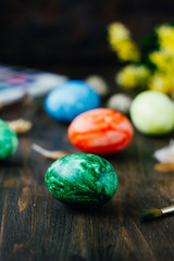 Green easter egg over brown rustic table.