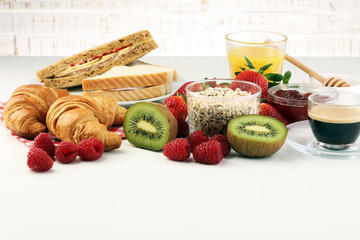 breakfast on table with sandwiches, croissants, coffe and juice