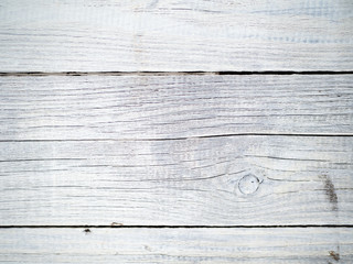 Wooden background of old fence with rusty nails. Shabby texture of white colored wooden boards.