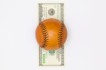 Leather baseball ball and us dollar banknotes.