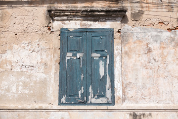 Old blue window in horizontal composition with a old dirty wall