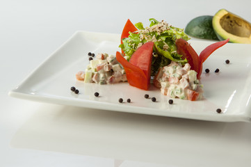 salad with avocado in a plate on a white background