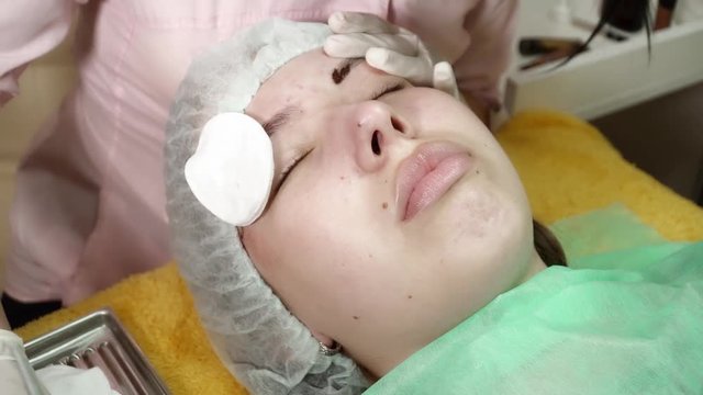 Beautician is making a microblading brocedure in salon closeup