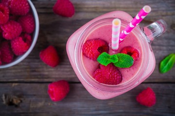 Raspberry smoothie in mason jar on rustic wooden background