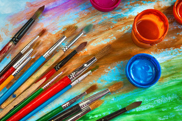 Artistic paint brushes and water color on a dark background