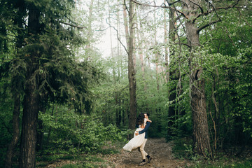 Wedding couple are walking in the forest