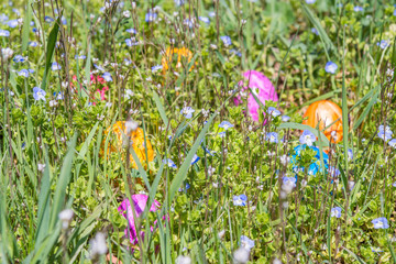 Bunte Ostereier auf gr&uuml;nem Gras mit sch&ouml;nen fr&uuml;hlings Blumen