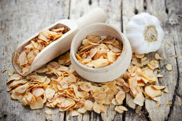 Dried garlic flakes or garlic chips and raw garlic bulb