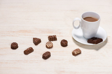 Glass of chocolate milk and variety chocolates  on table