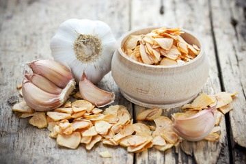 Dried garlic flakes or garlic chips and raw garlic bulb - Powered by Adobe