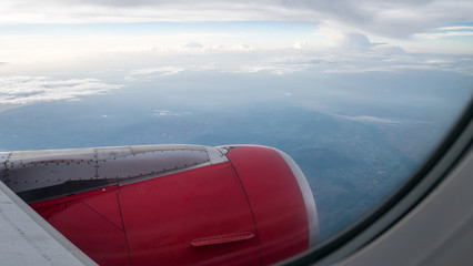 Fototapeta na wymiar The engine cowling of airplane on the beautiful cloudy and sky view from airplane window.