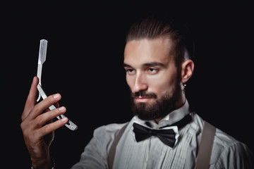Portrait of handsome man posing for photographer in studio, Dangerous razor,