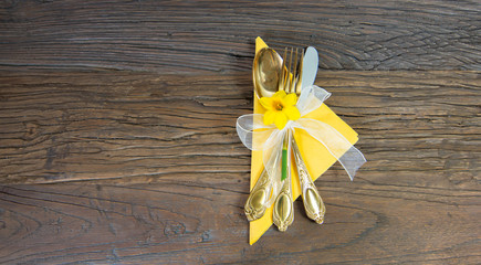 Easter concept : festive table setting. Holidays background. Gold cutlery, yellow napkin, narcissus...