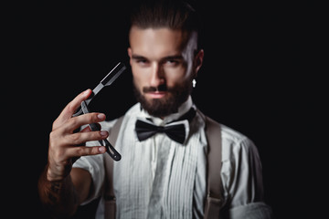 Portrait of handsome man posing for photographer in studio, Dangerous razor,