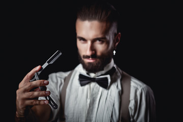 Portrait of handsome man posing for photographer in studio, Dangerous razor,