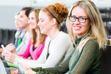 Studenten machen sich Notizen zu einem Vortrag im Universität Auditorium