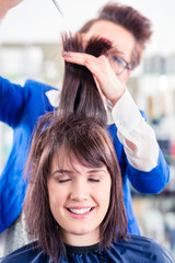 Friseur schneidet Frau die Haare im Friseursalon
