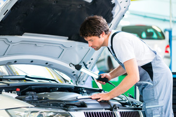 KFZ-Mechaniker arbeitet mit Werkzeug in Autowerkstatt